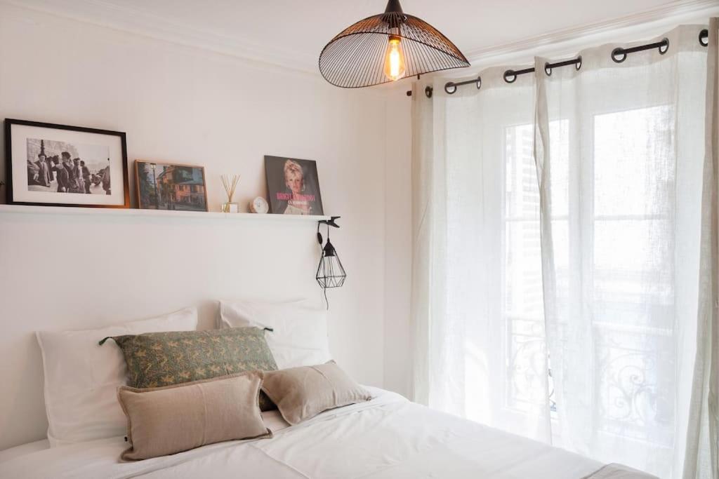 een slaapkamer met een wit bed en een raam bij CUTE & COSY 1BDR HOTEL DE VILLE / LE MARAIS in Parijs
