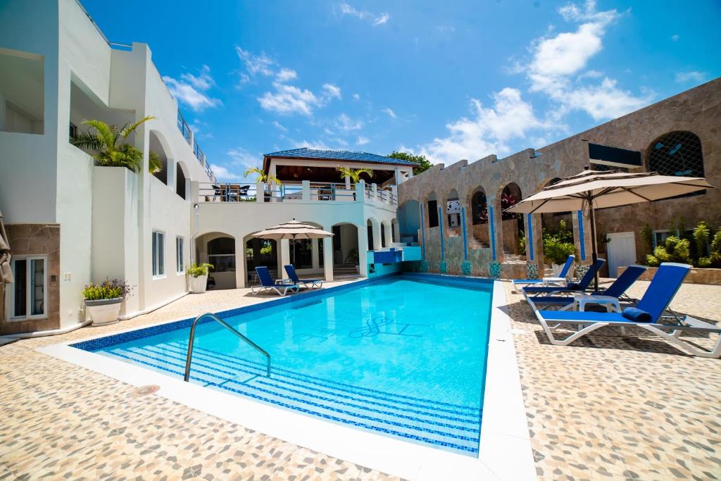 ein Pool in einem Haus mit zwei Stühlen und einem Sonnenschirm in der Unterkunft High Life Resort & Spa in Struie