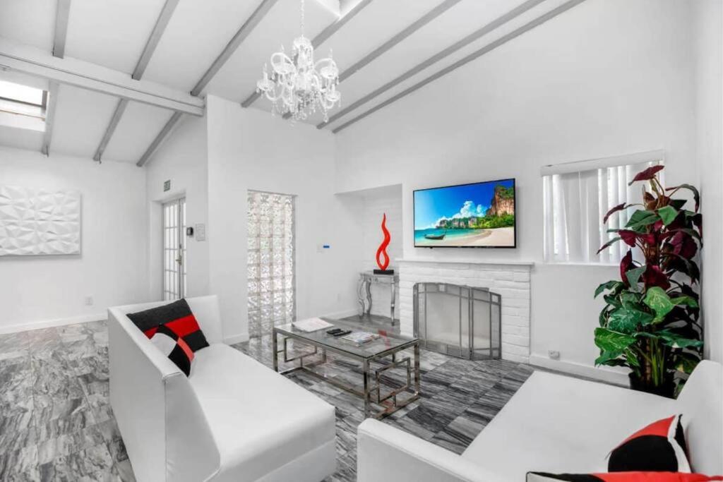 uma sala de estar com mobiliário branco e uma lareira em Bright Luxe Home Central Area em Miami