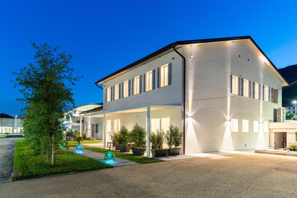 a large white building with a tree in front of it at TommyHouse in Borso del Grappa