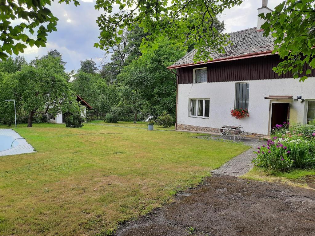 a white house with a yard next to it at Apartmány Waldex in Jetřichovice
