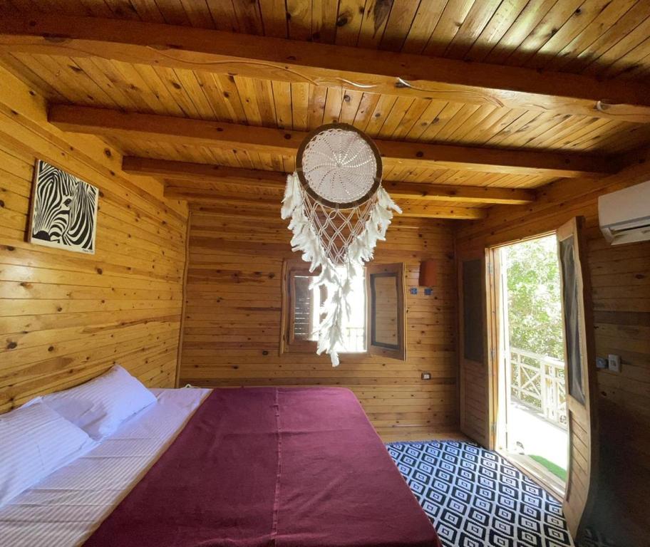 ダハブにあるDream house dahabの木製の部屋にベッド1台が備わるベッドルーム1室があります。