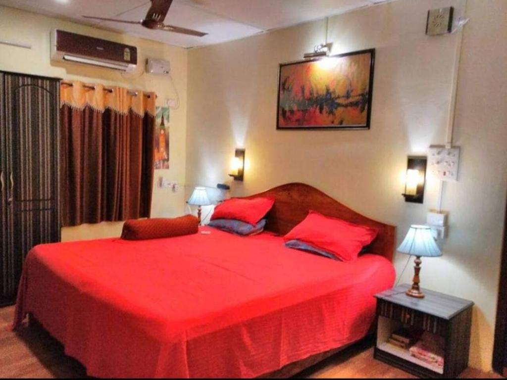 1 dormitorio con 1 cama roja y 2 almohadas rojas en Imperial Heritage Home en Port Blair