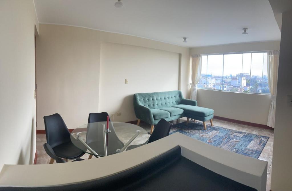 uma sala de estar com cadeiras, um sofá e uma janela em santa emma 701 em Lima