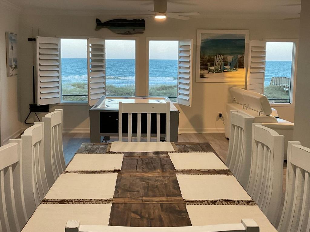 uma sala de jantar com mesa e cadeiras e o oceano em Auberge d'Amelia em Fernandina Beach