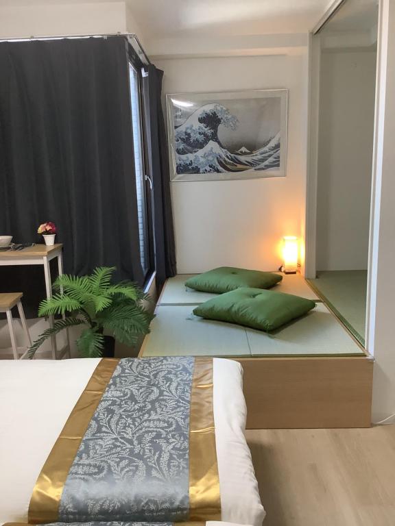 - une chambre avec 2 lits et des oreillers verts dans l'établissement 遊泊天王寺YupaStay, à Osaka
