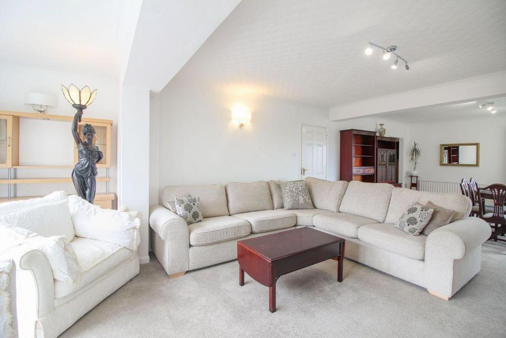 a living room with two white couches and a statue at Clifton Villa in Newquay