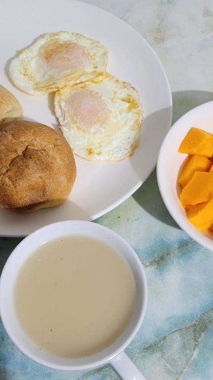 a plate of eggs and bread and a cup of milk at Apartment studio fotografico in Huancayo