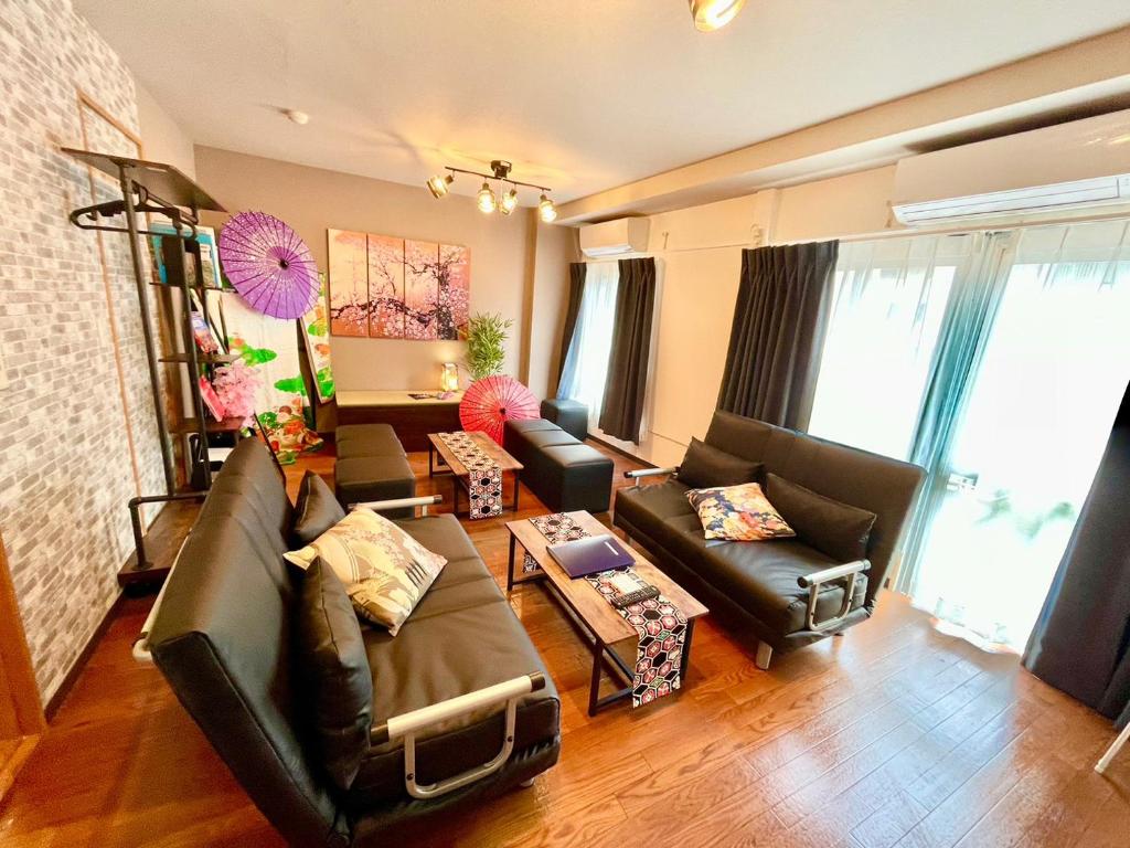 uma sala de estar com um sofá e uma mesa em Linkit Stay 東新宿 em Tóquio