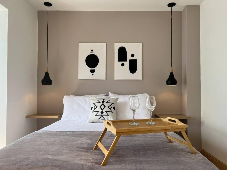 1 dormitorio con 1 cama y 1 mesa con copas de vino en Loft Iconic de lujo en Sabaneta, en Sabaneta