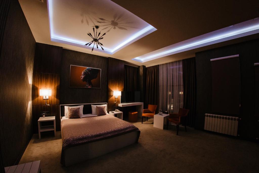 a bedroom with a bed and a ceiling with lights at Hillmond's Boutique in Baku
