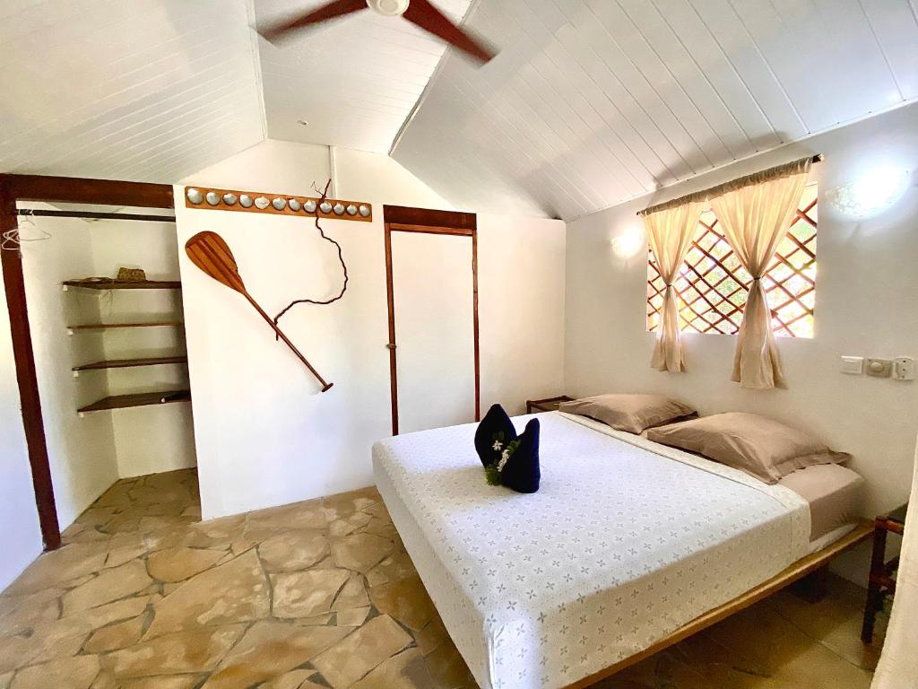 um quarto com uma cama e uma ventoinha de tecto em Poe Guesthouse em Avatoru