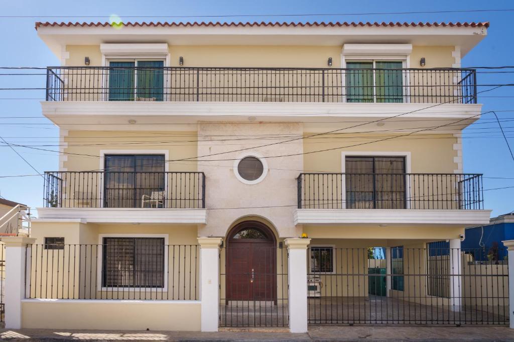 a tall yellow building with a balcony on top at Beautiful Three Storage House Near Playa Caleta in La Romana