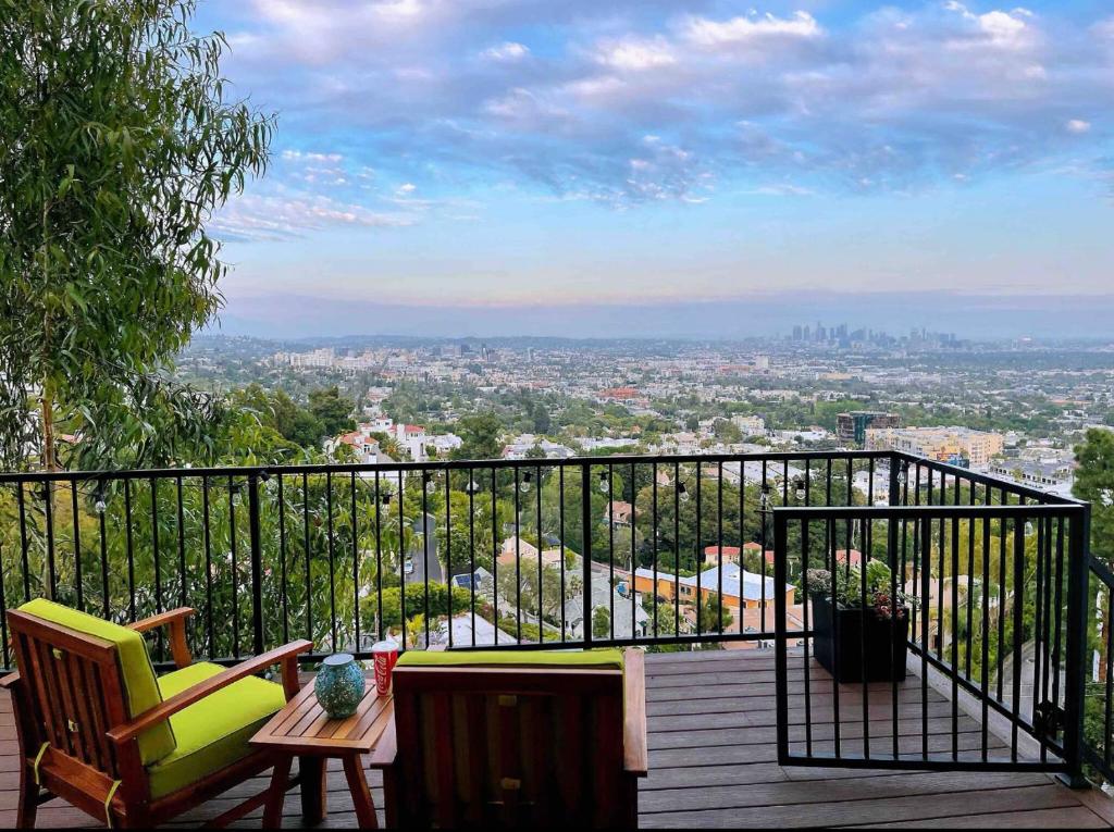 Stunning View Hollywood Hills Guest House في لوس أنجلوس: بلكونه فيها كراسي وطاولة وإطلالة على مدينة