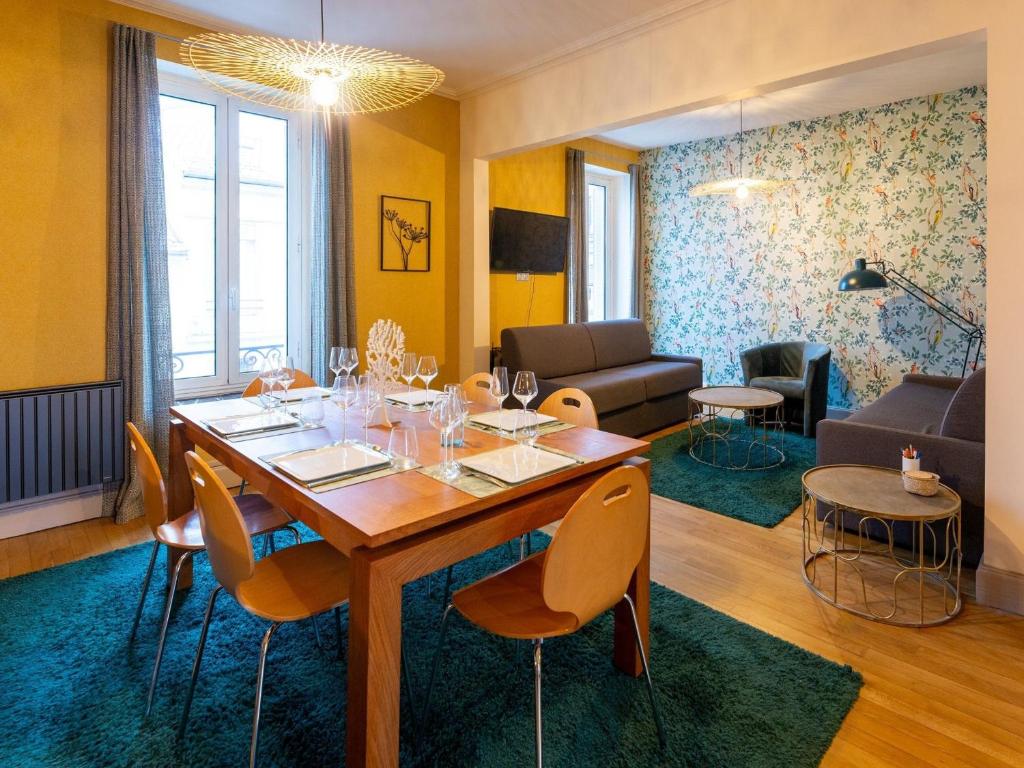 uma sala de estar com uma mesa de madeira e cadeiras em Gîte Nancy, 4 pièces, 6 personnes - FR-1-584-294 em Nancy