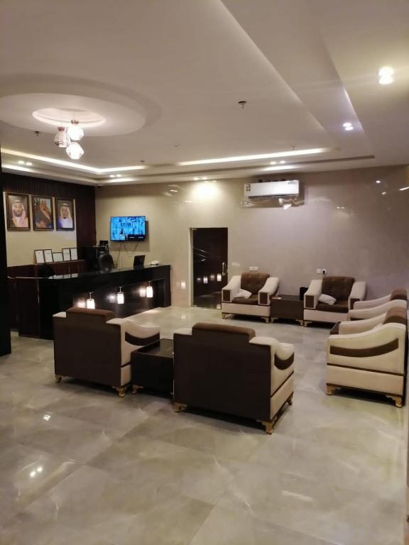 una sala de espera con sofás, mesa y TV en فندق اضواء المدينة en Sīdī Ḩamzah