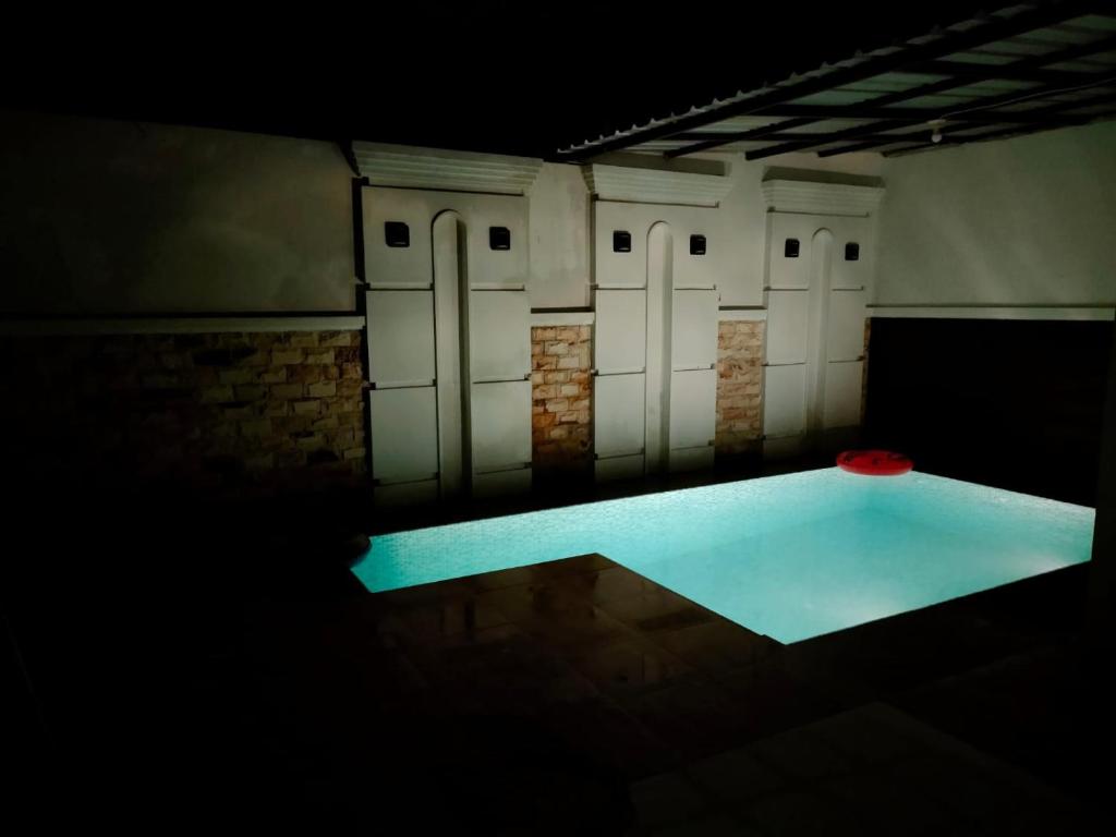 a dark room with a row of lockers and a pool at Villa Omakost3probolinggo in Probolinggo