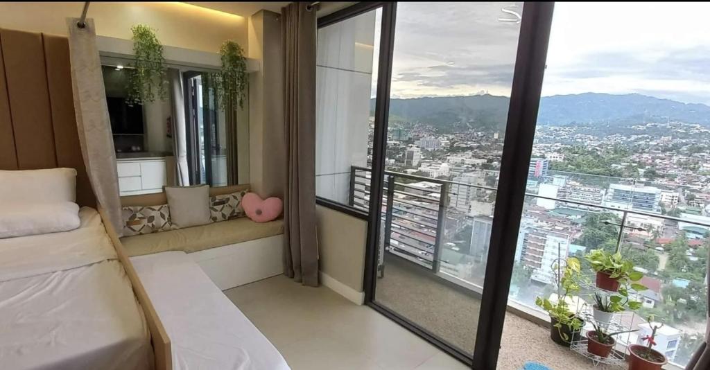 a room with a bed and a large window at Midtown Cebu City Condo in Cebu City