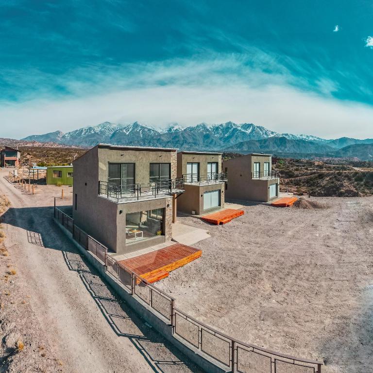 a house under construction with mountains in the background at Reflejo del Lago - Cabañas frente al Dique Potrerillos in Ciudad Lujan de Cuyo