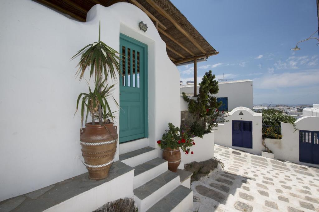 a green door on a white house with potted plants at Hibiscus Rosa Mykonos in Mikonos