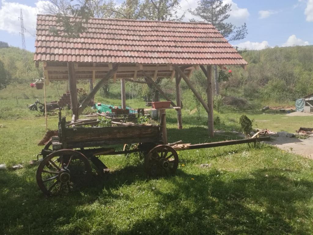 an old cart with a roof on a field at Etno Konak Angela in Kalna