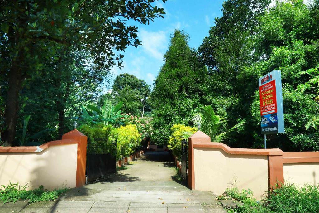 een loopbrug in een park met een bord op een hek bij Back Packers Cochin Villa in Cochin