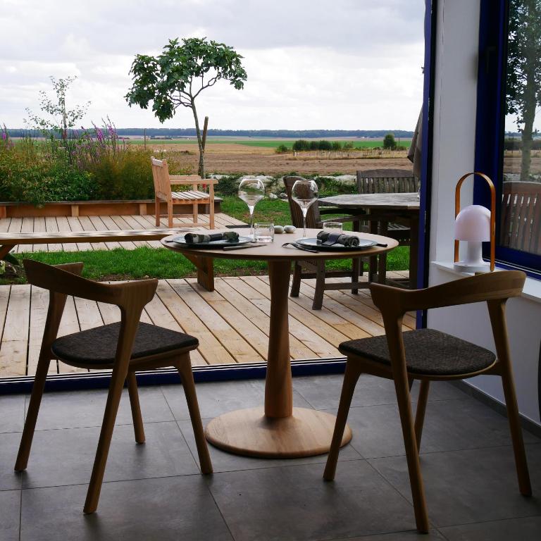 une table et des chaises sur une terrasse avec vue dans l'établissement Maison HOUX, à Dominois