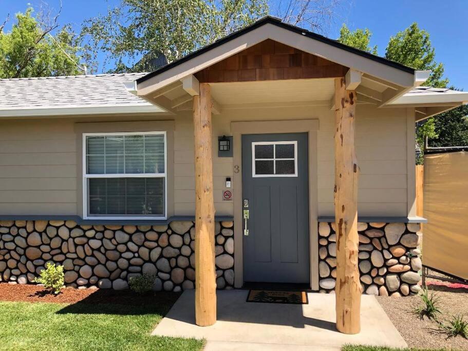 uma casa com uma porta da frente com uma parede de pedra em Riverside Cabin 3 em Grants Pass