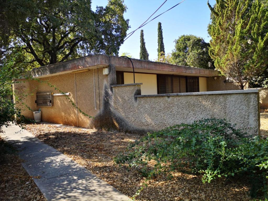 an old house in the middle of a yard at בית בטבעון in Ramat Hadassa