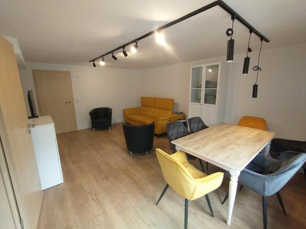 a living room with a wooden table and chairs at Schicke hundefreundliche Wohnung in Alsheim