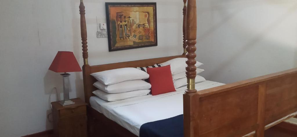 1 dormitorio con 1 cama con marco de madera en Habarana INN, en Habarana