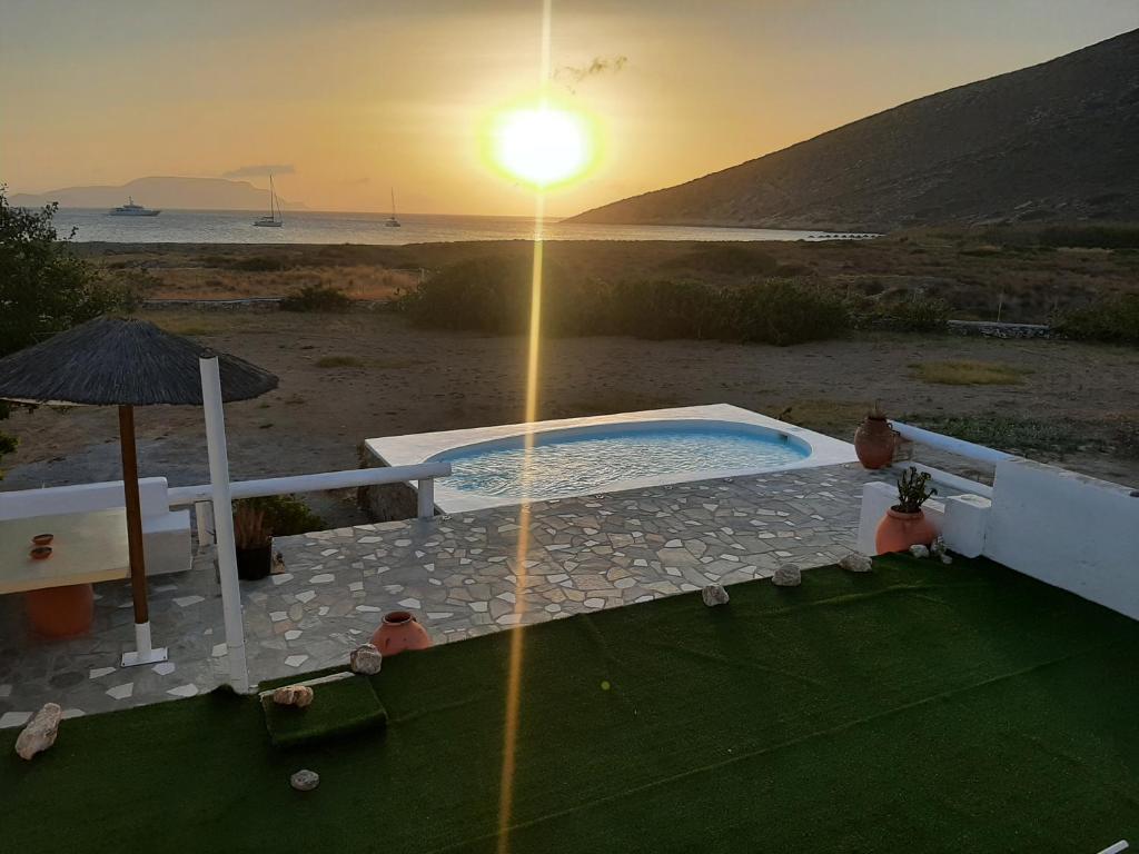 Traditional House by The Beach في Agia Theodoti: حوض استحمام ساخن على الشاطئ مع غروب الشمس