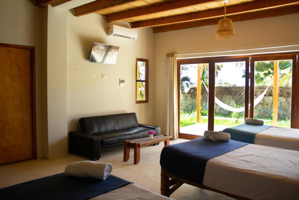 een woonkamer met 2 bedden en een bank bij Panorama garden inn in Máncora