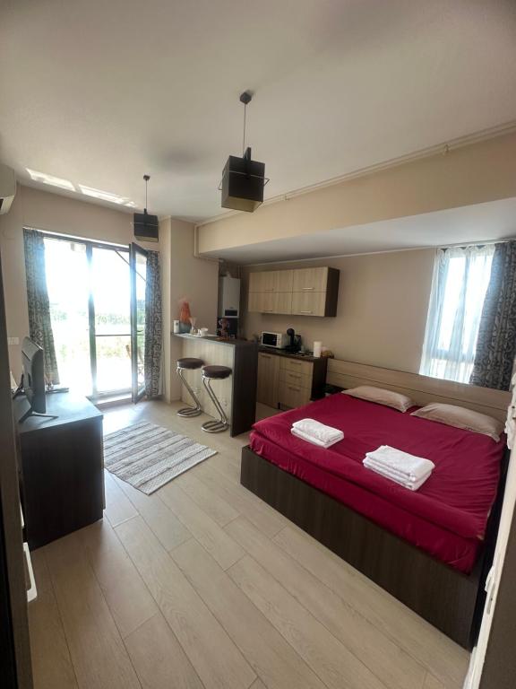 een slaapkamer met een rood bed en een keuken bij GGMamaia in Mamaia