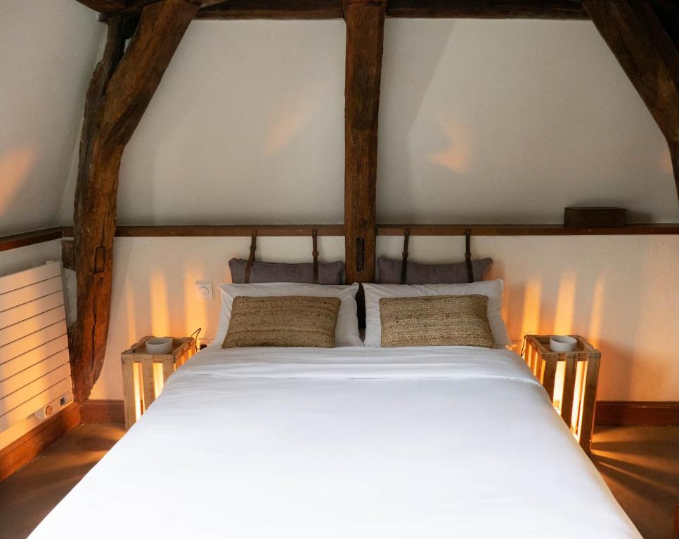 a bedroom with a large white bed with wooden beams at Suite Toussaint - Calme &amp; Authentique in Angers