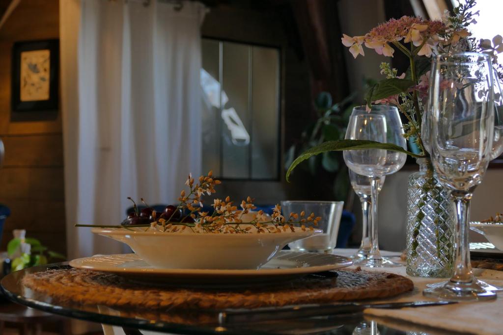 a table with a bowl of flowers on a table at Suite Toussaint - Calme &amp; Authentique in Angers