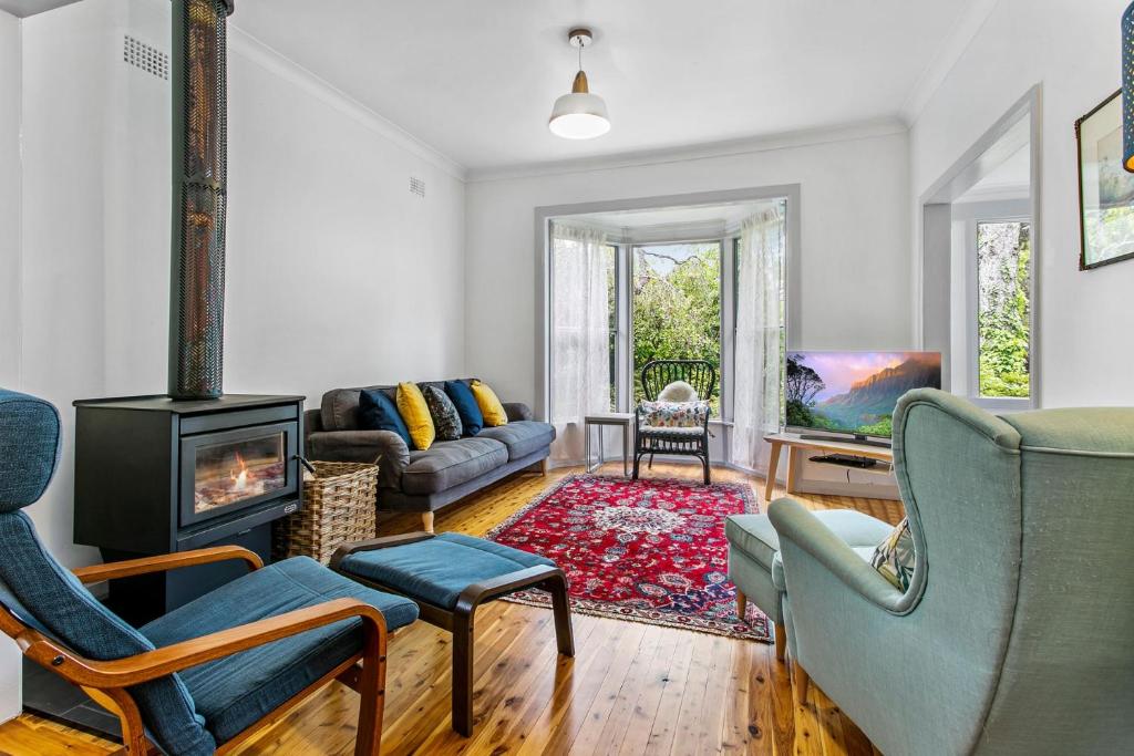 Garden Cottage في ليورا: غرفة معيشة مع أريكة ومدفأة