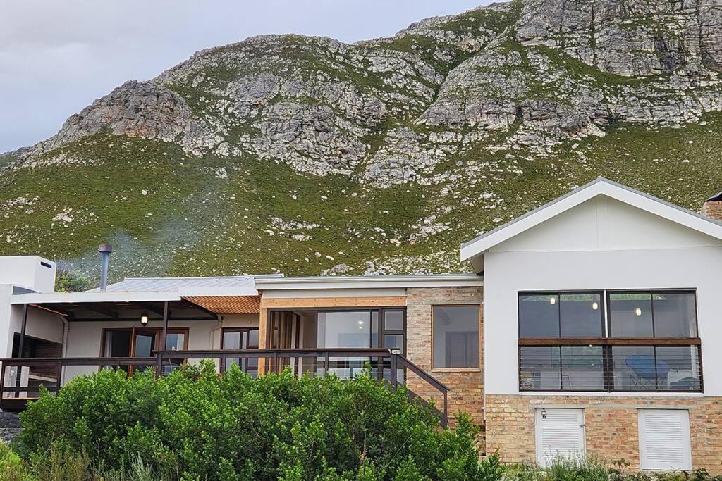 a house with a mountain in the background at Jock's Bay View in Bettyʼs Bay