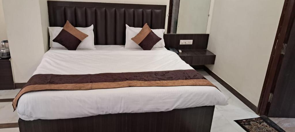 a bedroom with a large bed with a wooden headboard at Hotel Govindam Elite in Juhi Bari
