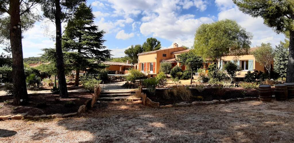 a house with trees in front of a yard at Chambre privée, piscine, pool house, cuisine d'été in La Ciotat