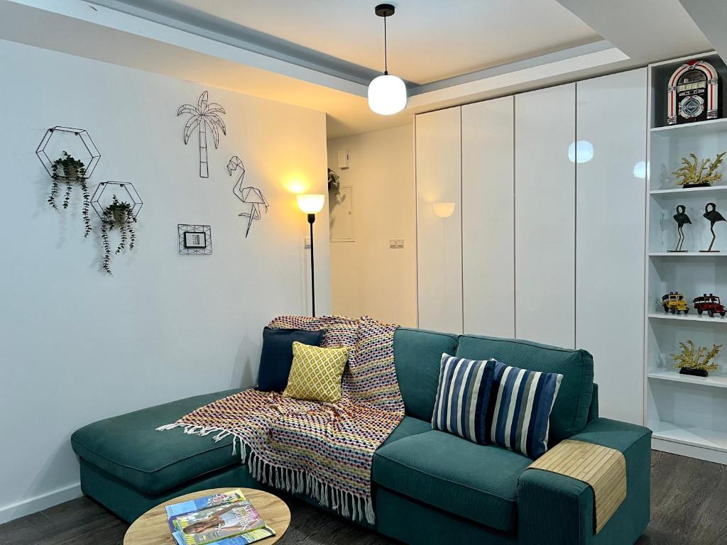 sala de estar con sofá verde y mesa en Fat Cow Apartment 01 en Lárnaca