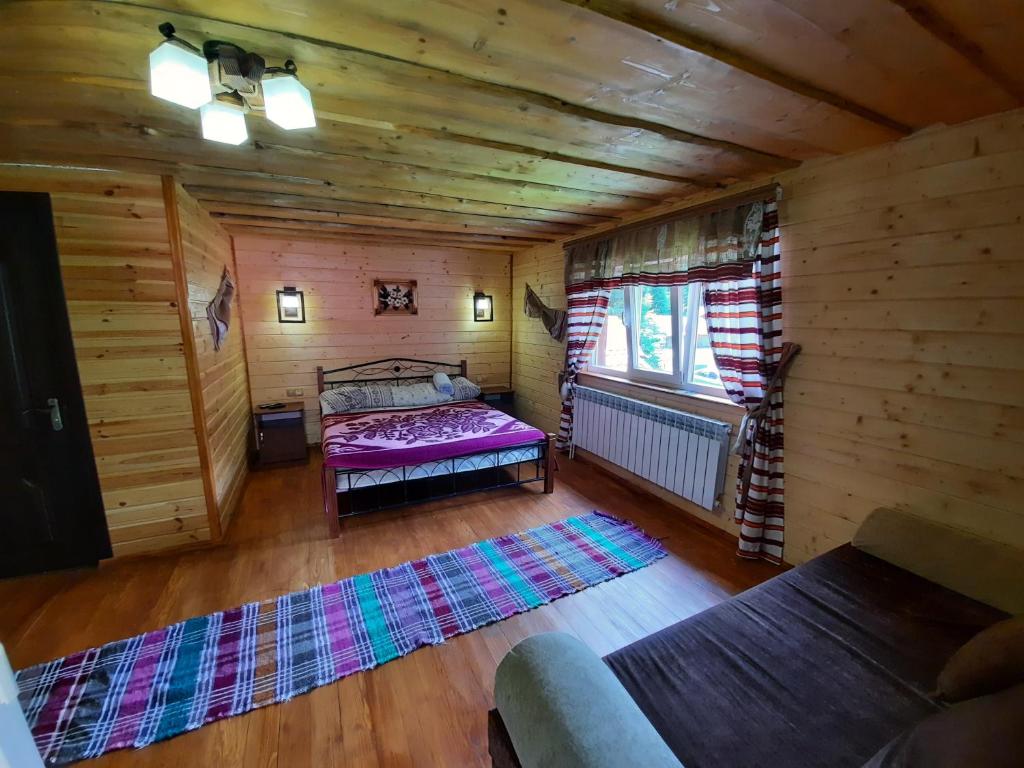 een slaapkamer met een bed in een houten hut bij Садиба У Ані номер 4 in Synevyrsʼka Polyana