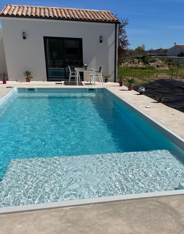 a swimming pool in front of a house at Love room in Gémozac