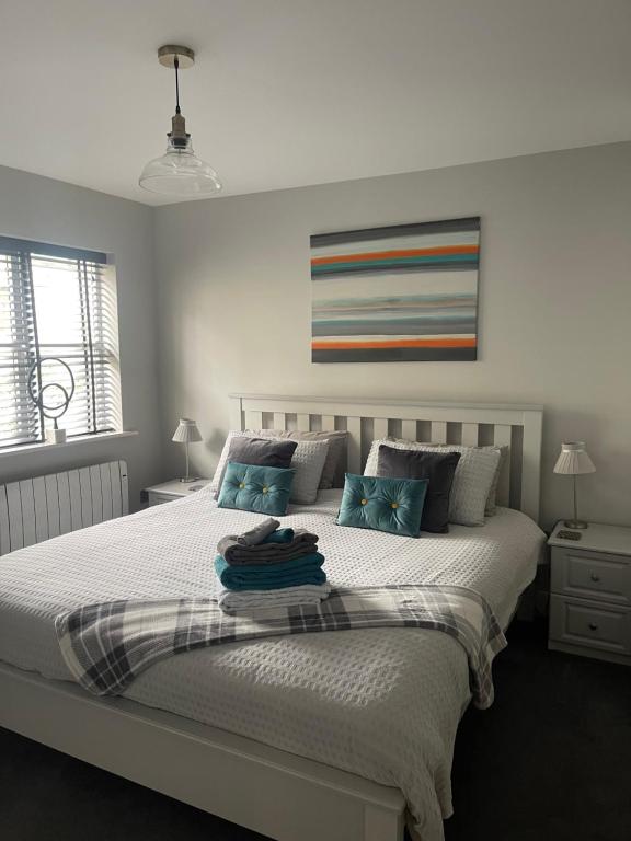 1 dormitorio con 1 cama grande con almohadas azules en 4 The Archways, en Carrick on Shannon