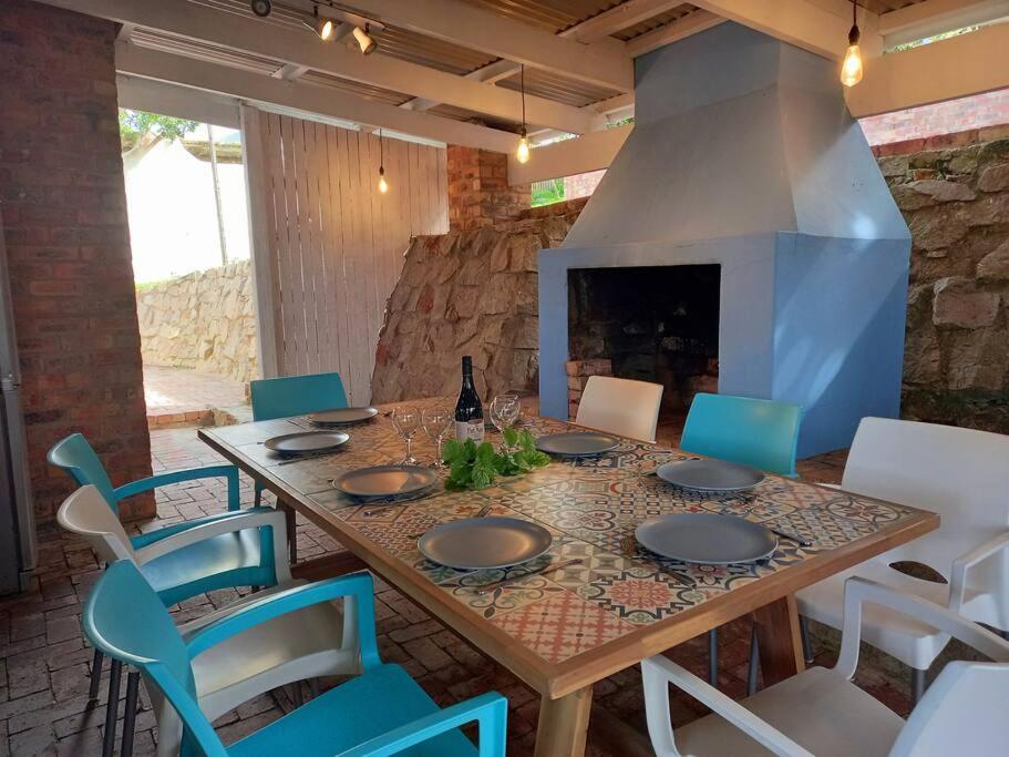 a wooden table with chairs and a fireplace at Cloud 9 : Where you can daydream in Kenton on Sea