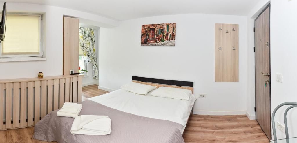 a bedroom with a bed with two white towels on it at Aparthotel Metropol in Iaşi