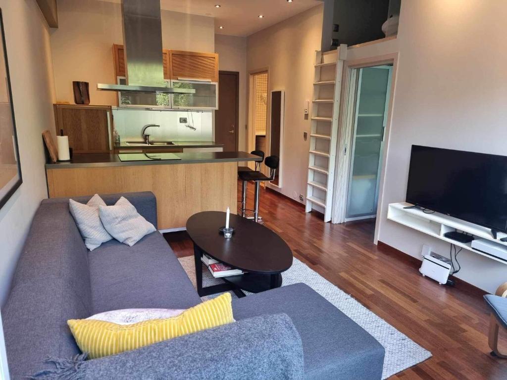 una sala de estar con un sofá y una mesa en Kjekk urban leilighet, en Stavanger