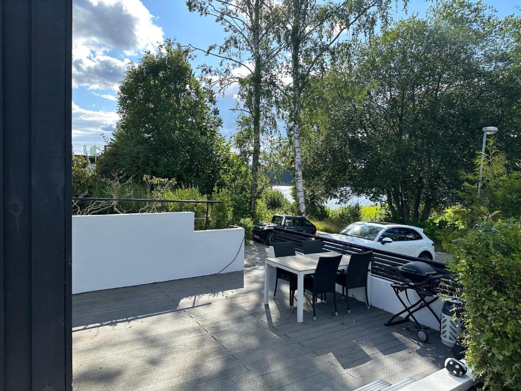 uma varanda com uma mesa e cadeiras e um carro em Studio house with sea view in Stockholm em Tyresö
