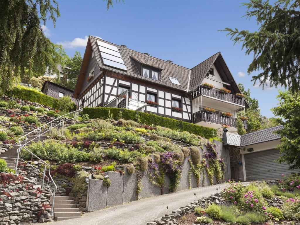 a house on the side of a hill with flowers at Cosy apartment in Hallenberg near centre in Hallenberg
