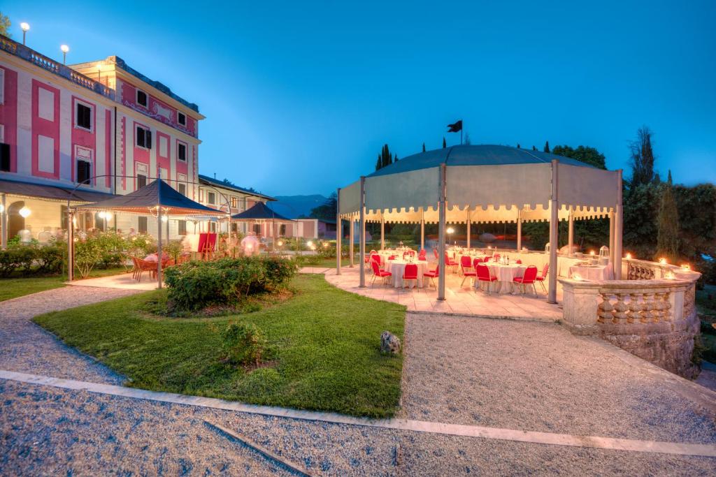 un patio con mesas y sillas y un edificio en Park Hotel Villa Potenziani, en Rieti